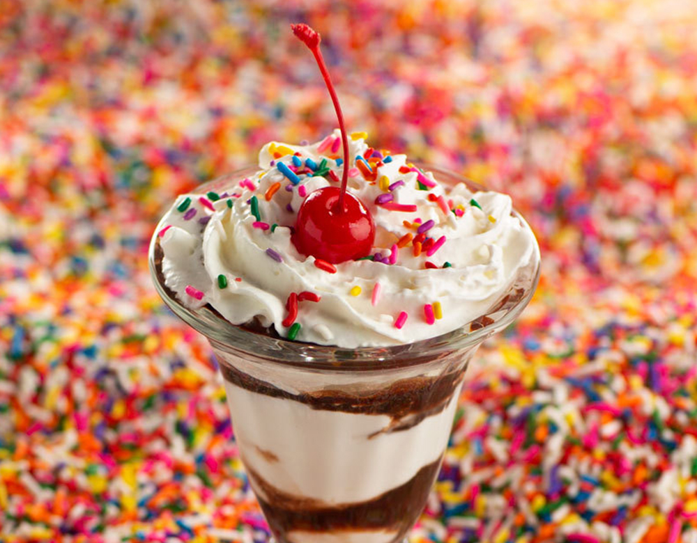 Sprinkles falling on and around a Kids' Birthday Sundae