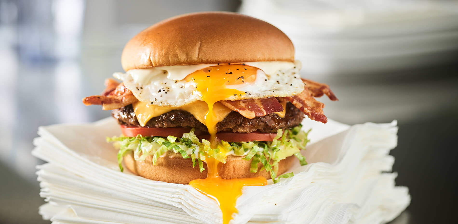 Royal Red Robin Burger dripping yolk onto stack of napkins