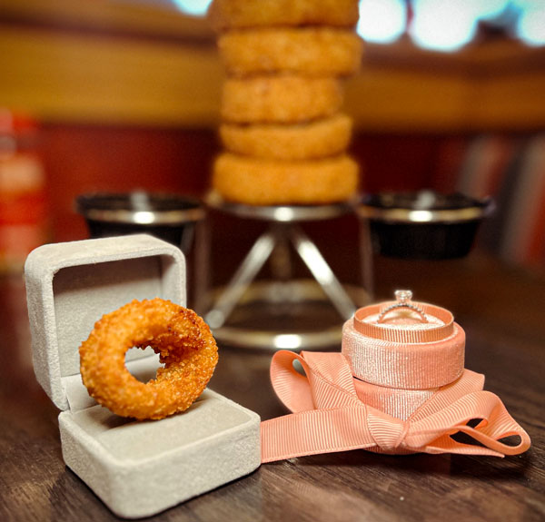 Onion ring in ring box sitting next to diamond ring